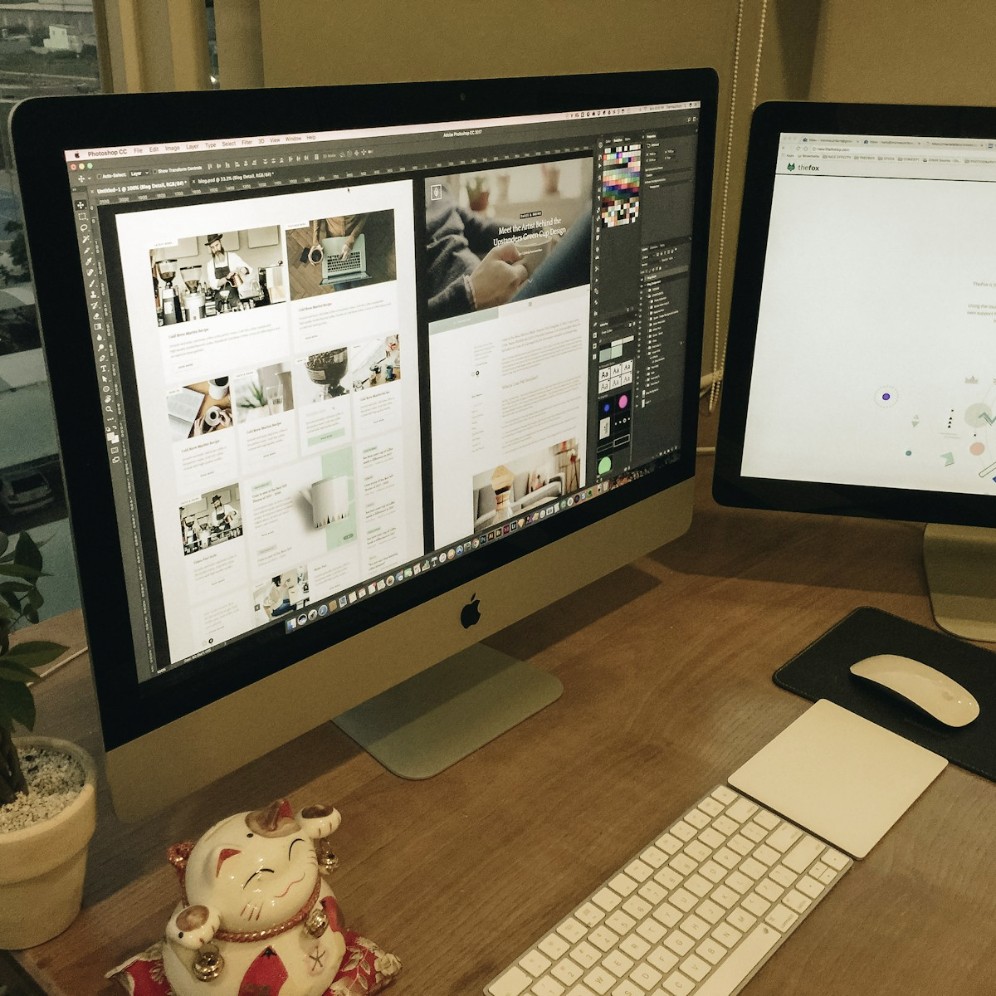 A desk with two computer monitors and a keyboard